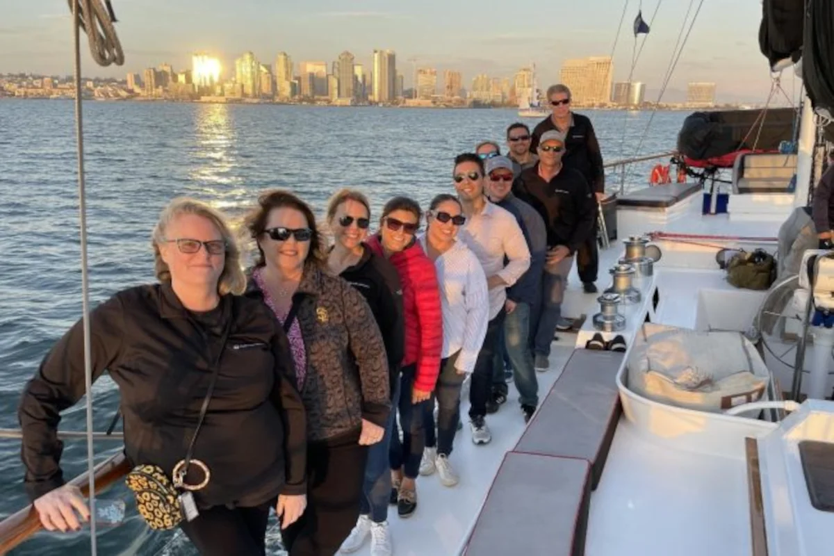 Diagonal row of smiling friends on deck