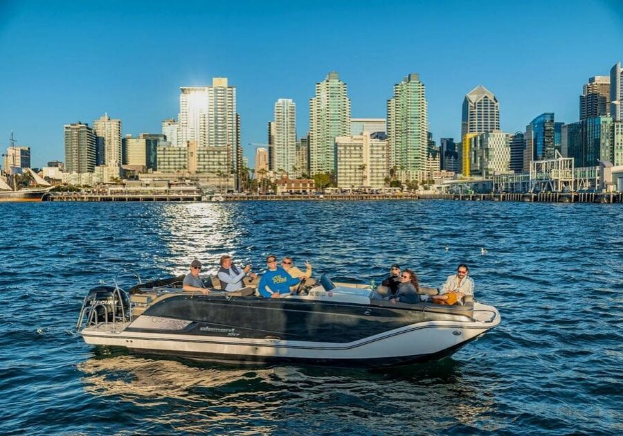 People enjoying a sunny day on a boat near a city skyline.
