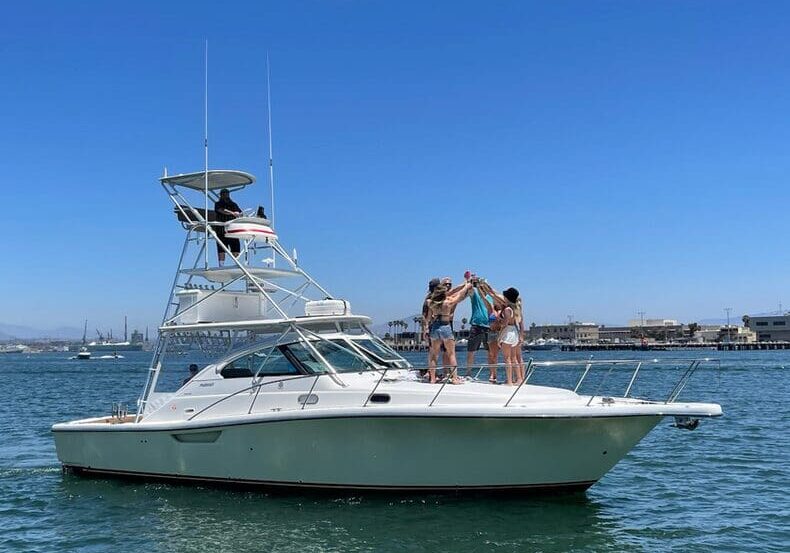 People enjoying a sunny day on a white yacht at sea.