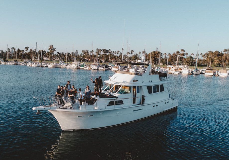 A group of people on a white yacht in a marina.