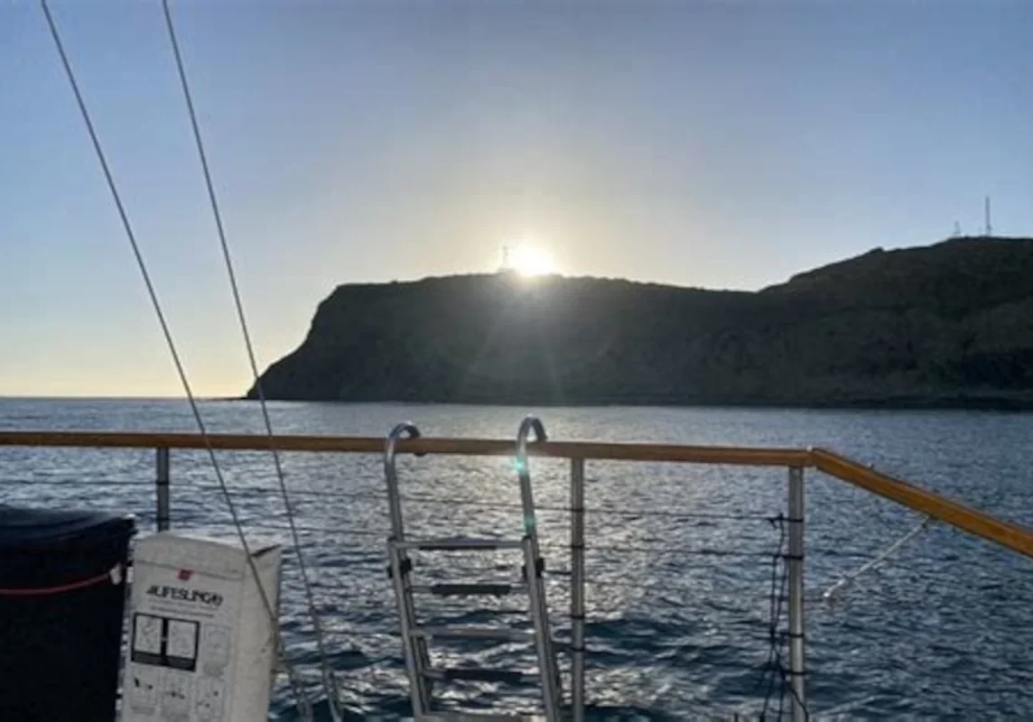 Sailboat stern with ladder at sunrise