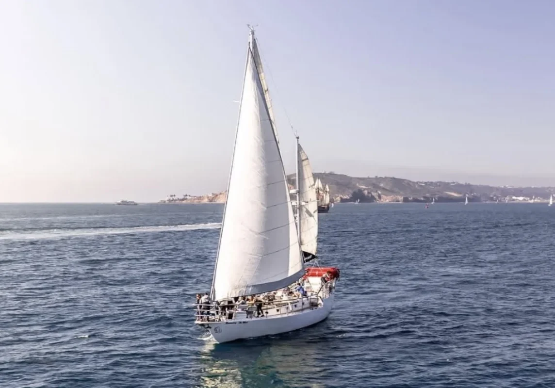 Tall-masted yacht sailing on calm blue ocean