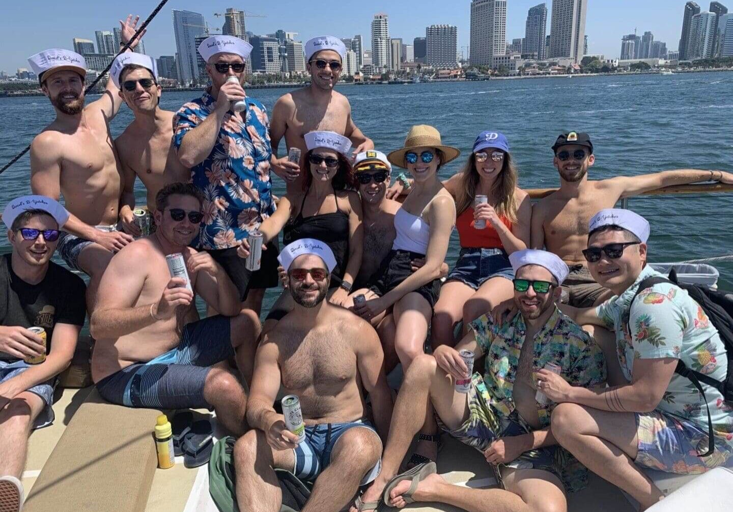 Group wearing sailor hats boating by city skyline