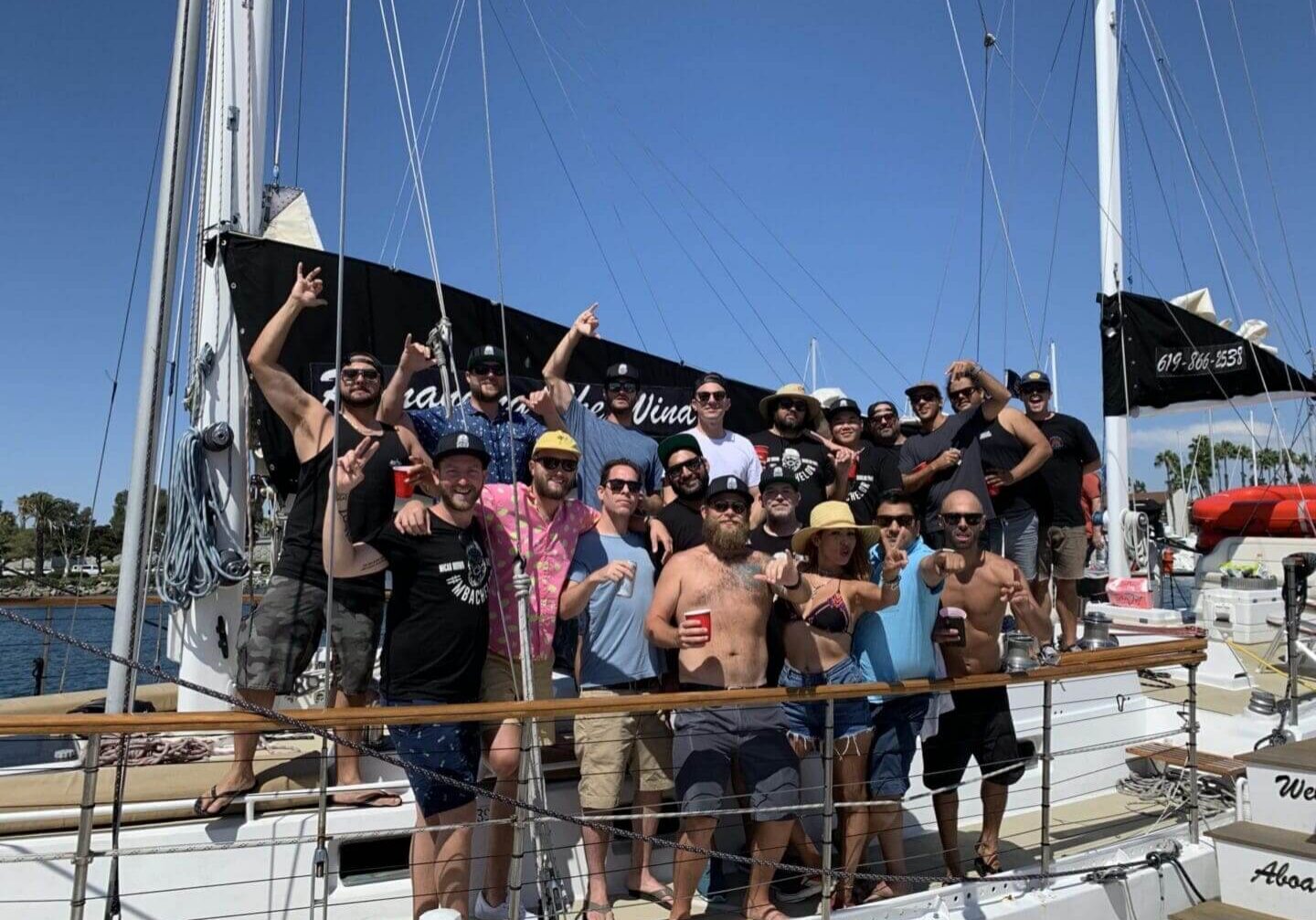 Group of people celebrating on a boat under clear blue sky.