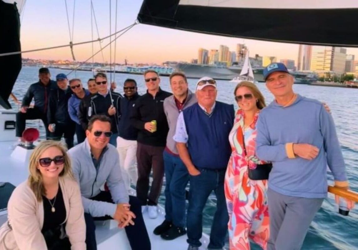 Smiles on yacht deck with urban harbor