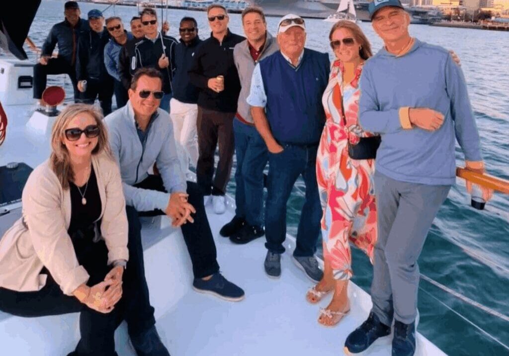 Group of friends posing on a boat during sunset.
