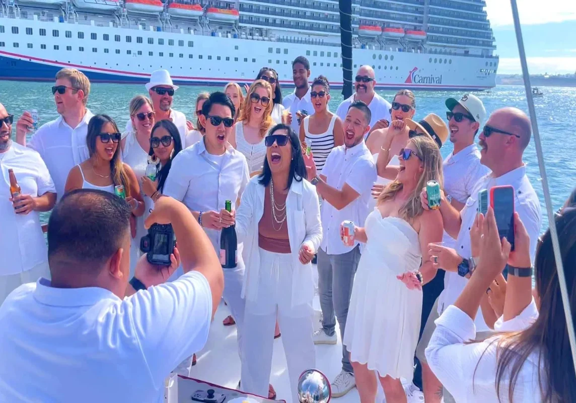 Group celebrating on deck beside a cruise ship