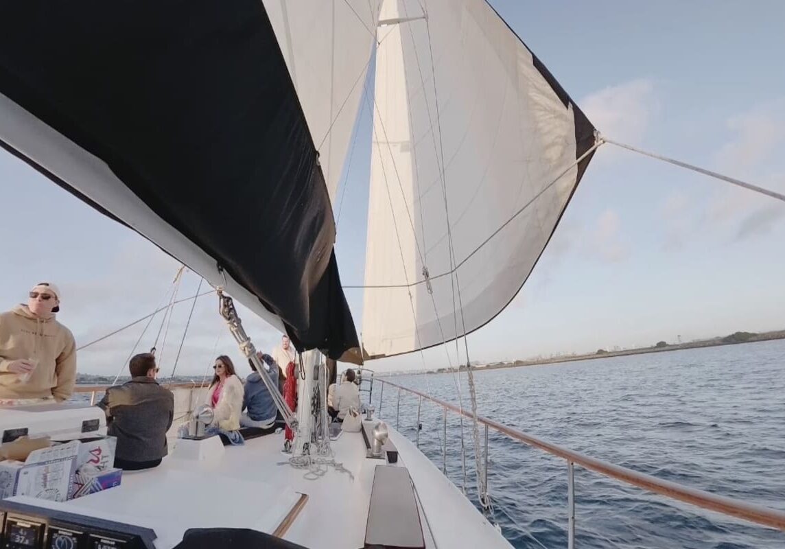 Group lounging on deck under billowing sail
