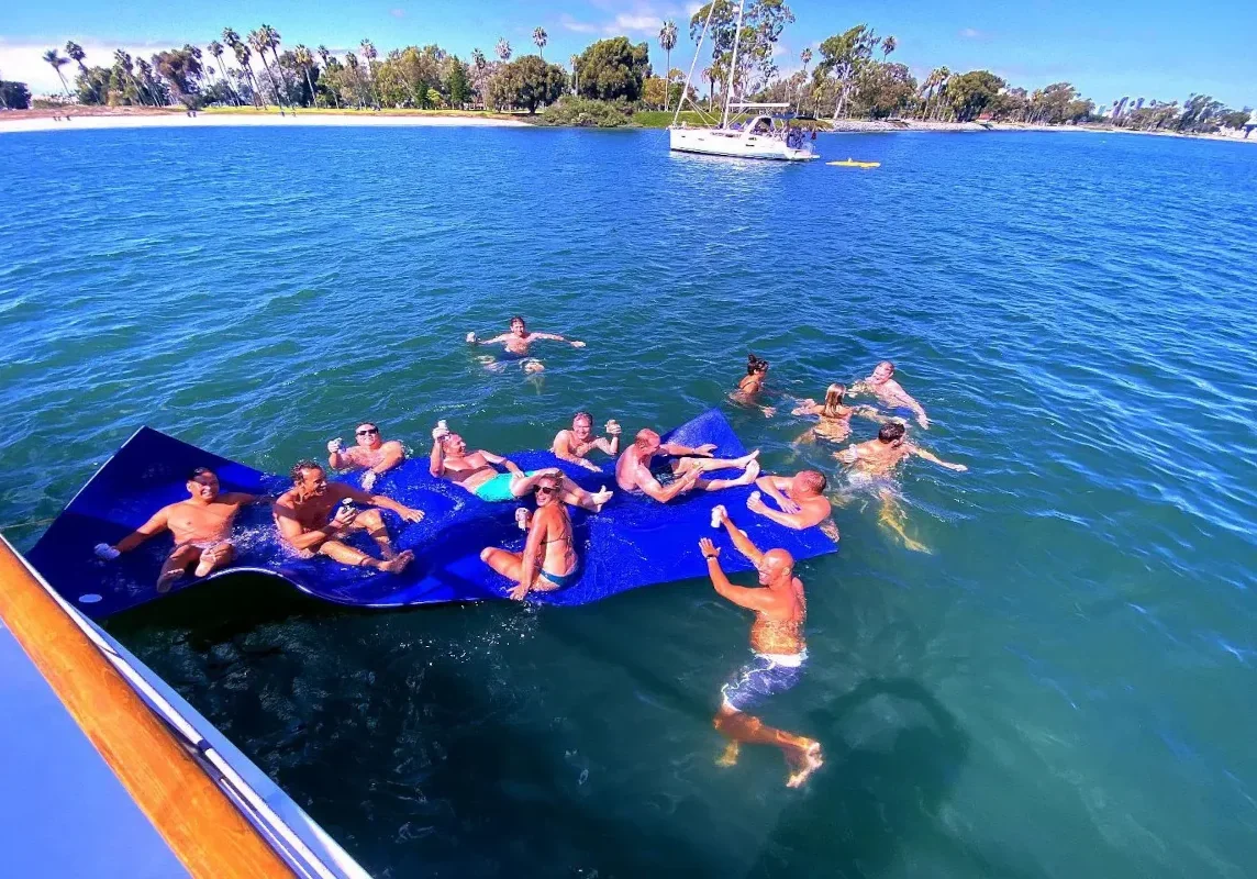 Sunny party on giant blue floating beach mat